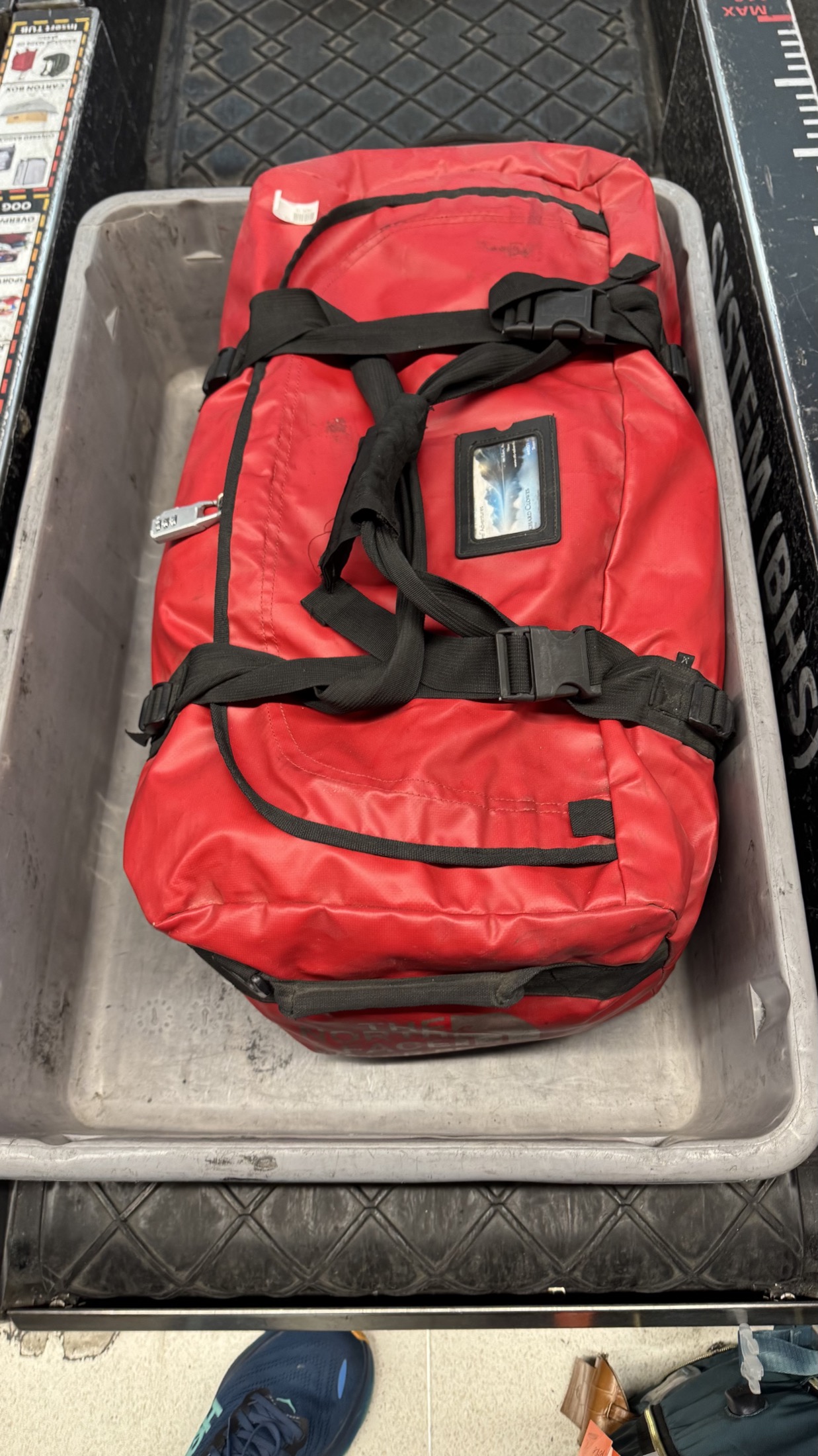 Red checked duffel in airport baggage tray