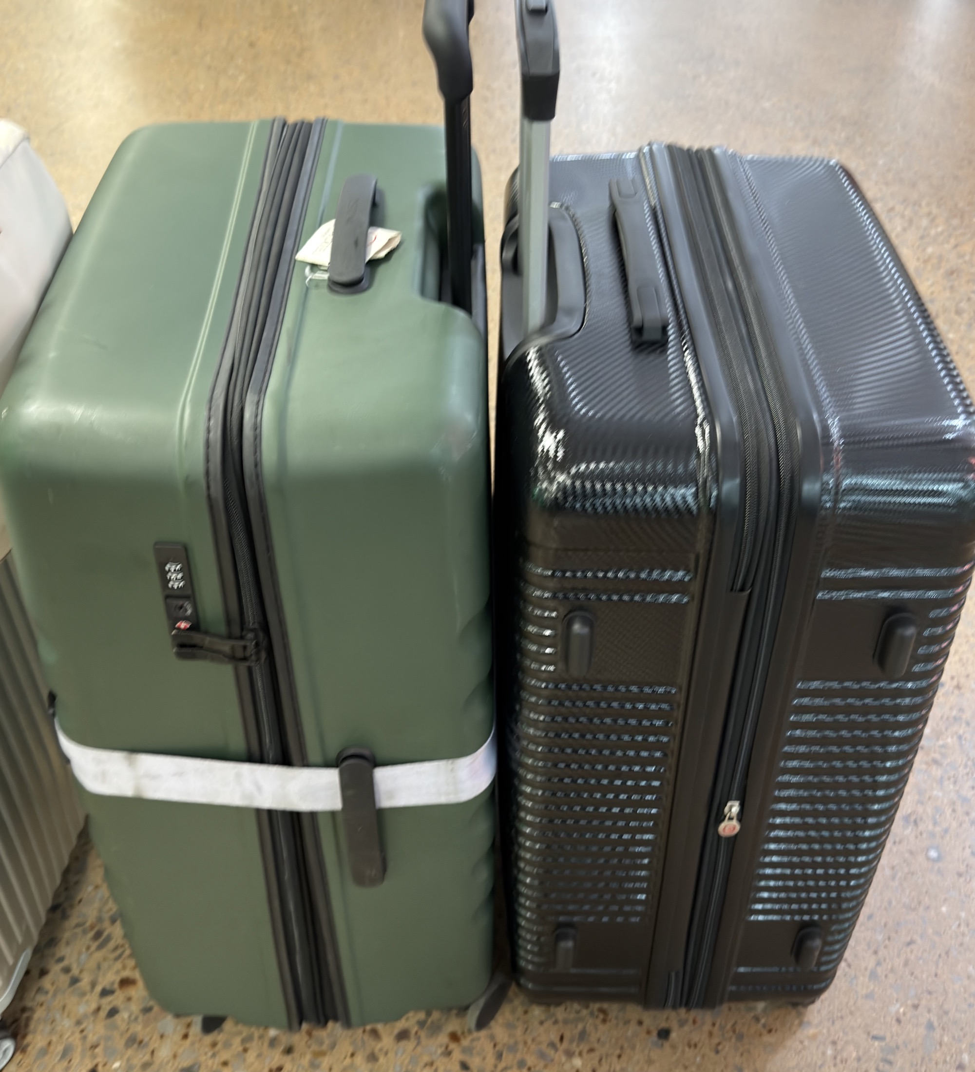 Two rolling suitcases standing together